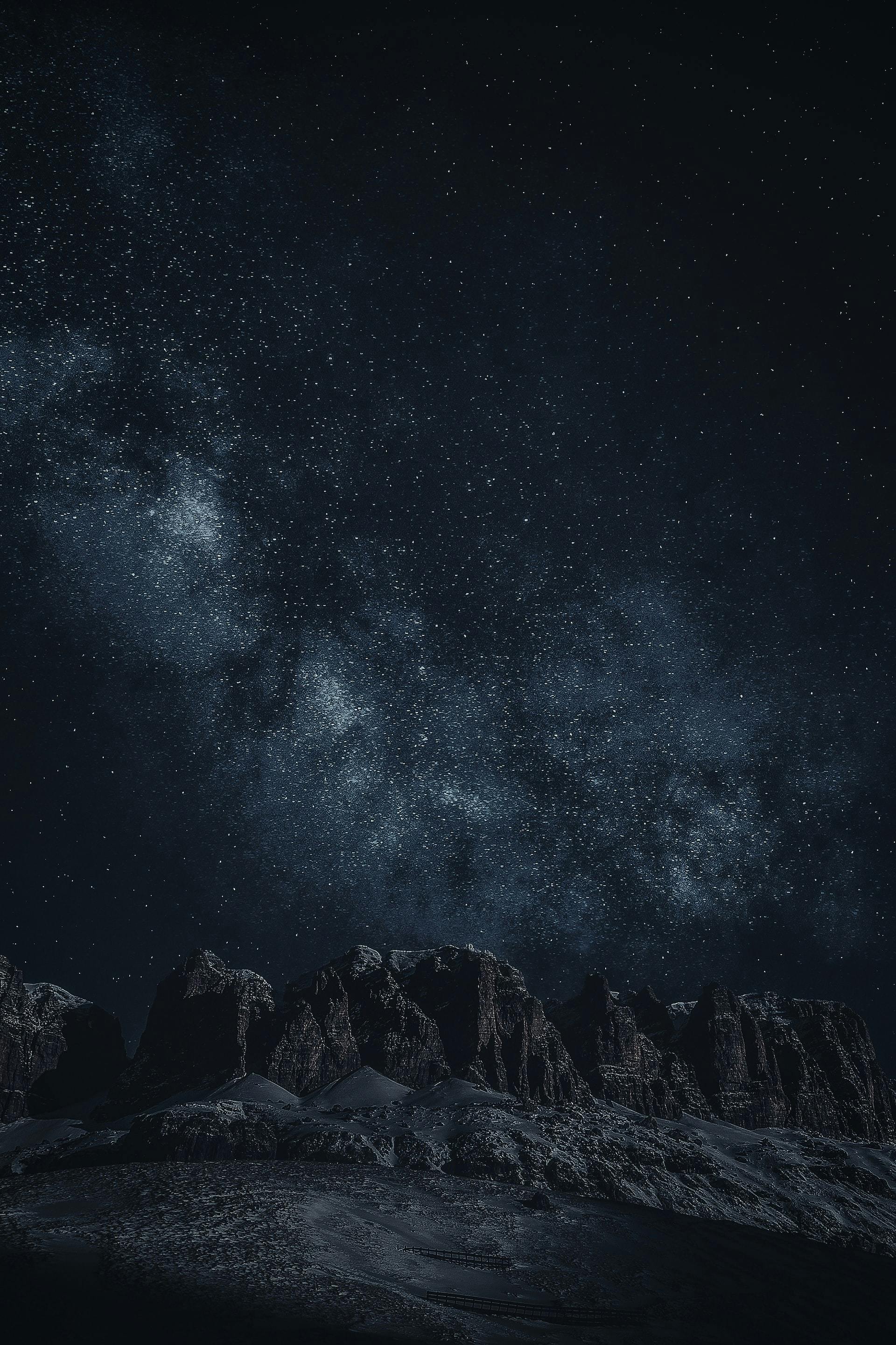 Night time shot of mountains with stars above.